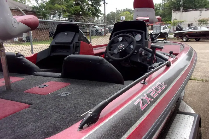Slide: The Image of 1996 Skeeter ZX200 boat interior with steering wheel and seating, parked outdoors. - 13