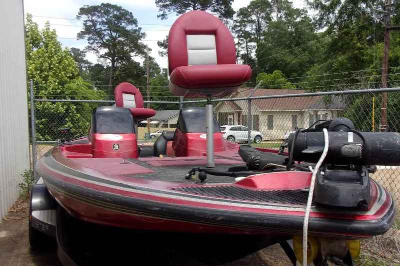 Slide: The Image of 1996 Skeeter ZX200 bass boat with red seats, parked outdoors near a fence. - 18