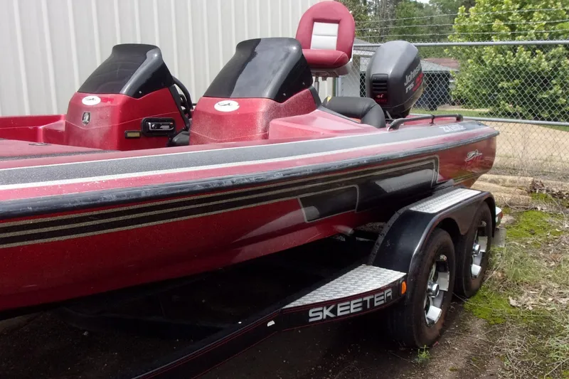 Slide: The Image of 1996 Skeeter ZX200 bass boat with dual consoles and trailer, parked outdoors. - 2
