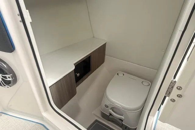 Slide: The Image of 2022 Regal LS6 Surf boat interior with compact marine toilet and storage. - 11