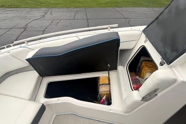 Slide: The Image of 2022 Regal LS6 Surf boat storage compartments with open seats, showcasing interior space. - 17