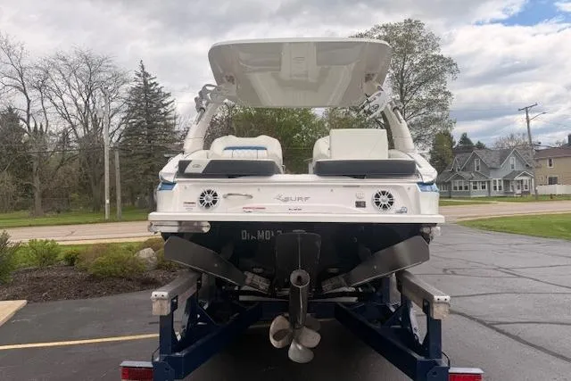 Slide: The Image of 2022 Regal LS6 Surf boat on trailer, rear view, parked outdoors. - 2