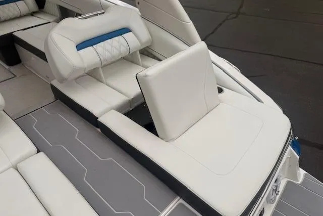 Slide: The Image of 2022 Regal LS6 Surf boat interior with white and blue cushioned seating. - 28