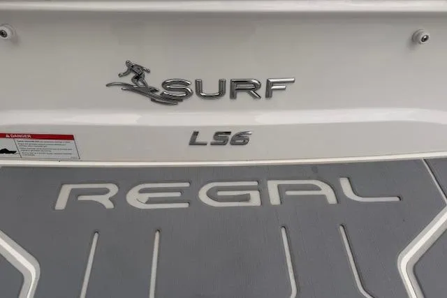 Slide: The Image of 2022 Regal LS6 Surf boat branding on deck, showcasing sleek design and logo. - 30