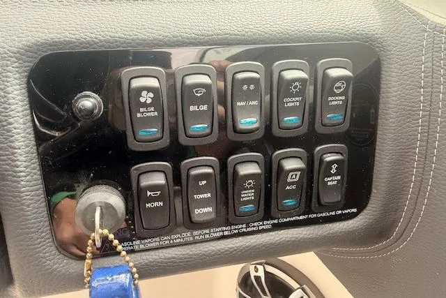 Slide: The Image of Control panel of a 2022 Regal LS6 Surf boat with various switches and key. - 7