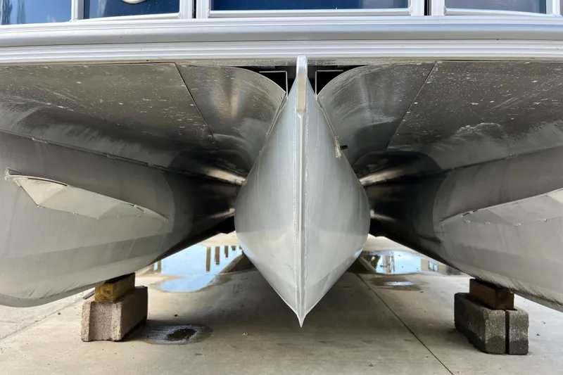 Slide: The Image of Underneath view of a 2023 South Bay 224 RS pontoon boat on blocks. - 19