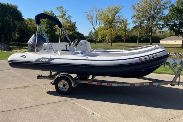 The Image of 2013 AB Inflatables Nautilus 17 boat on trailer, parked outdoors on a sunny day. - 0
