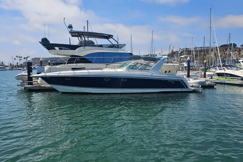 Slide: The Image of 2003 Formula 41 Performance Cruiser docked at a marina under a clear blue sky. - 2