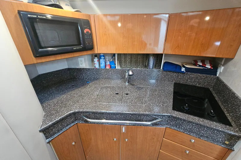 Slide: The Image of 2003 Formula 41 Performance Cruiser kitchen with microwave, sink, and stovetop. - 26