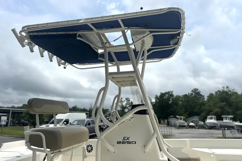 Slide: The Image of 2014 Skeeter SX2250 boat with T-top and seating, parked outdoors under cloudy skies. - 9