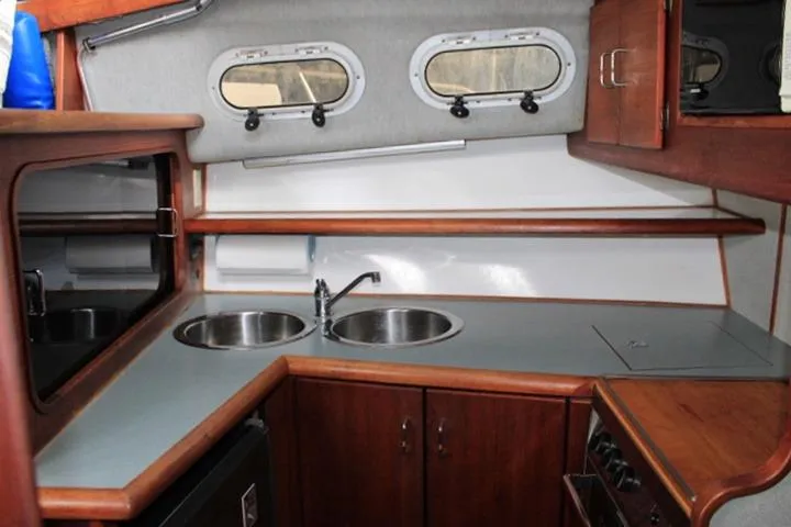 Slide: The Image of 1992 Bayliner 3288 Motoryacht kitchen with dual sinks, wooden cabinetry, and compact stove. - 36