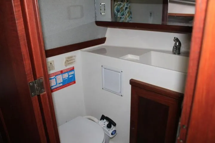 Slide: The Image of 1992 Bayliner 3288 Motoryacht bathroom with sink, toilet, and wooden cabinetry. - 45