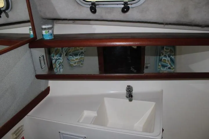 Slide: The Image of Bathroom sink area in a 1992 Bayliner 3288 Motoryacht with mirror and storage. - 46