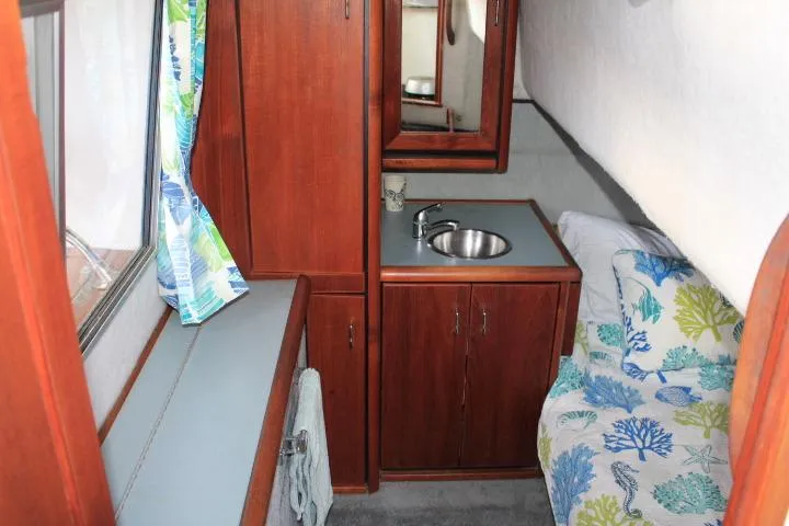 Slide: The Image of Interior of 1992 Bayliner 3288 Motoryacht with sink, cabinets, and patterned bedding. - 47