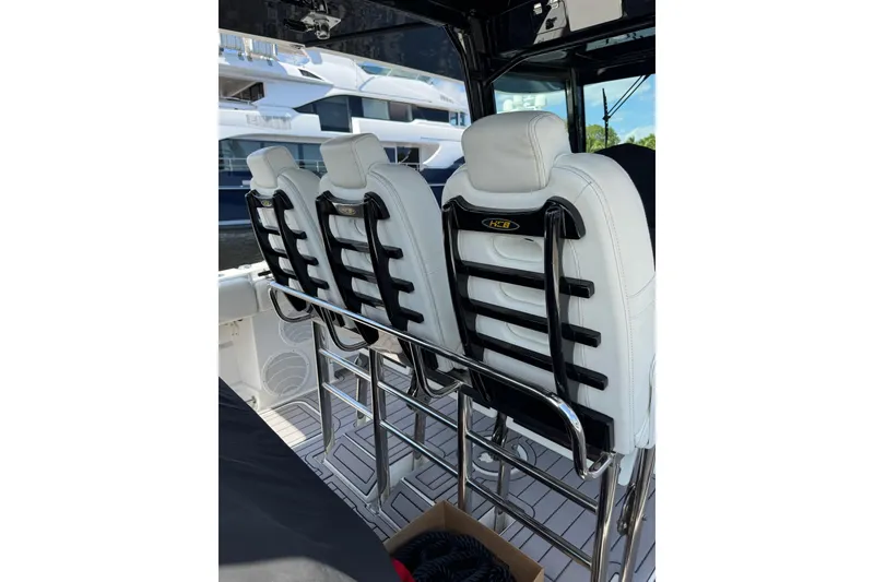Slide: The Image of Three white seats on a 2019 HCB 42 Siesta boat, featuring sleek design and chrome accents. - 15