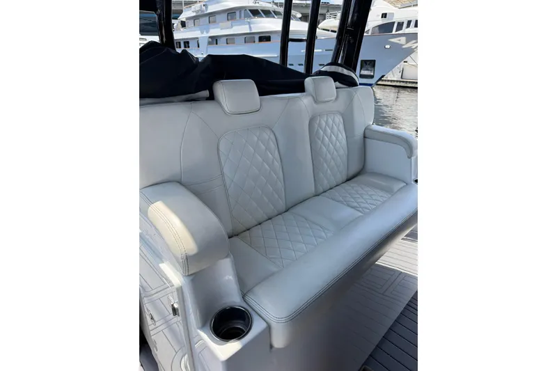 Slide: The Image of Luxurious white seating on 2019 HCB 42 Siesta boat, featuring diamond stitching and armrests. - 18