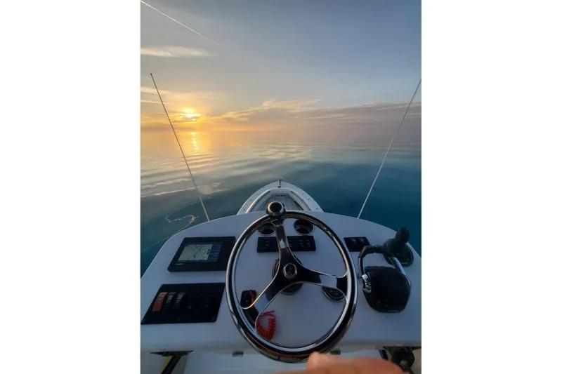 Slide: The Image of 2019 HCB 42 Siesta boat steering wheel with ocean sunset view. - 20