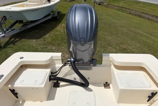 Slide: The Image of Jones Brothers Bateau 23 boat, 2026 model, with outboard motor on grassy area. - 4