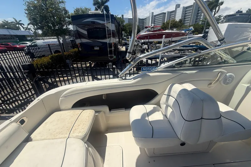 Slide: The Image of 2004 Sea Ray 215 Weekender boat interior with white seating and chrome railings. - 10