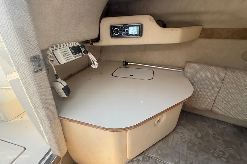 Slide: The Image of 2004 Sea Ray 215 Weekender cabin interior with radio and table setup. - 11