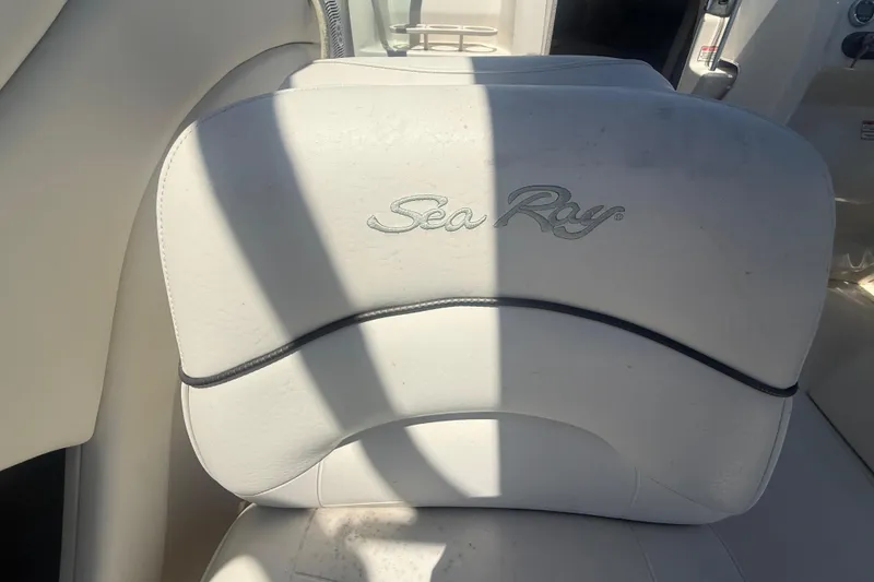 Slide: The Image of White leather seat with "Sea Ray" logo on a 2004 Sea Ray 215 Weekender boat. - 13
