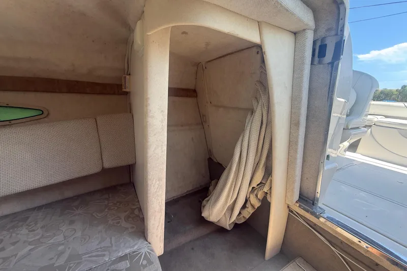 Slide: The Image of Interior cabin of a 2004 Sea Ray 215 Weekender boat, featuring seating and storage space. - 15