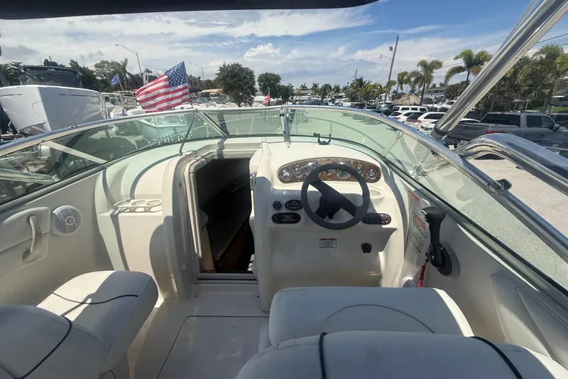 Slide: The Image of 2004 Sea Ray 215 Weekender boat interior with steering wheel and American flag. - 4