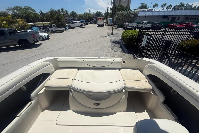Slide: The Image of 2004 Sea Ray 215 Weekender boat interior with cushioned seating, parked in a lot. - 5