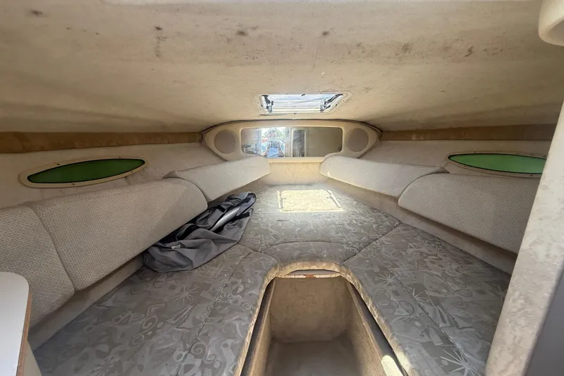 Slide: The Image of Interior cabin of a 2004 Sea Ray 215 Weekender boat, featuring cushioned seating. - 9
