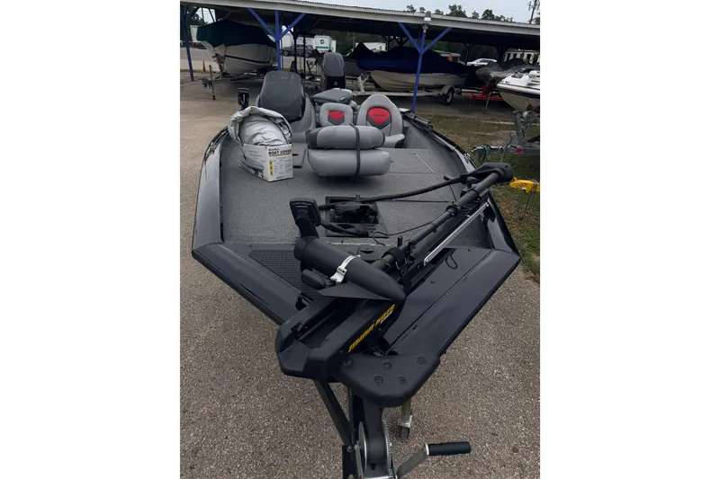 Slide: The Image of 2014 Tracker Pro Team 175 TXW boat with seating and equipment, parked outdoors. - 11