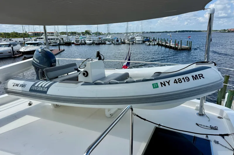 The Image of Inflatable boat with Yamaha motor docked on a yacht, overlooking a marina. - 1