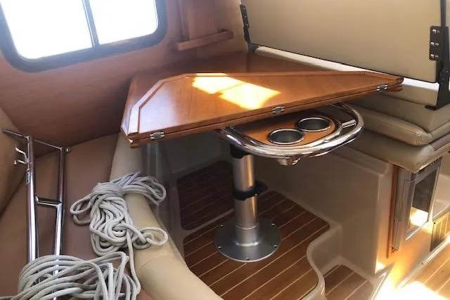 Slide: The Image of 2013 Ranger Tugs R-29 S interior with wooden table, cup holders, and coiled rope. - 24