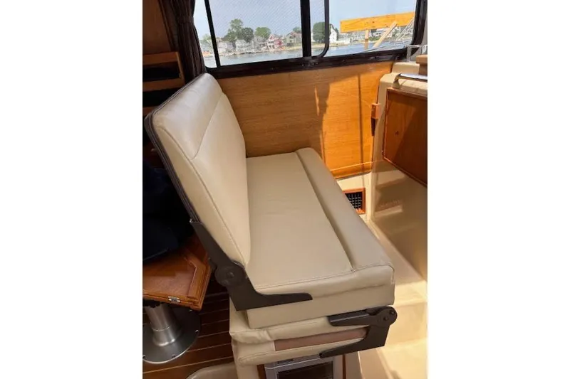 Slide: The Image of Interior seating of 2013 Ranger Tugs R-29 S boat, featuring beige upholstery and wooden accents. - 25