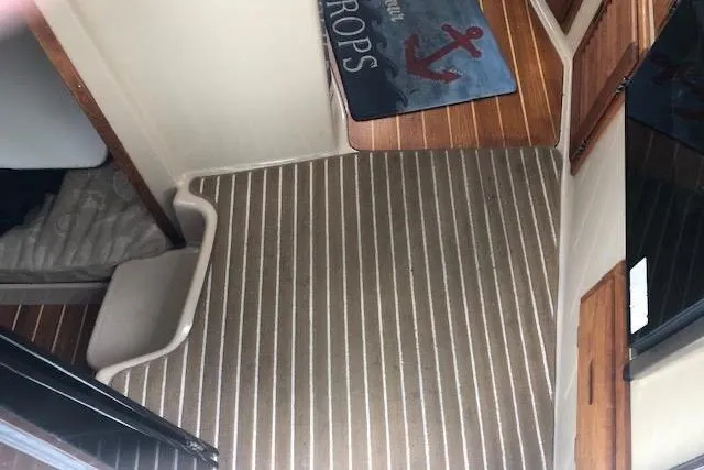 Slide: The Image of Interior of 2013 Ranger Tugs R-29 S with striped carpet and nautical-themed mat. - 28