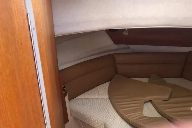 Slide: The Image of 2013 Ranger Tugs R-29 S interior cabin with cushioned seating and wooden accents. - 34
