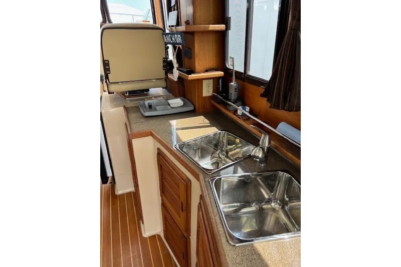 Slide: The Image of Interior of 2013 Ranger Tugs R-29 S, featuring a compact kitchen with dual sinks. - 50