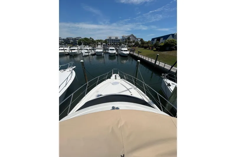Slide: The Image of 2001 Silverton 410 Sport Bridge yacht docked in a marina under a clear blue sky. - 11