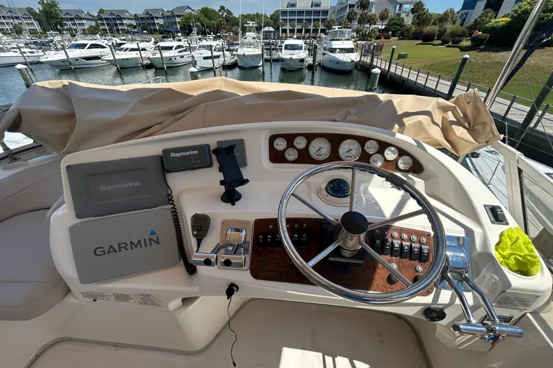 Slide: The Image of Helm of 2001 Silverton 410 Sport Bridge with Garmin and Raymarine navigation systems. - 13