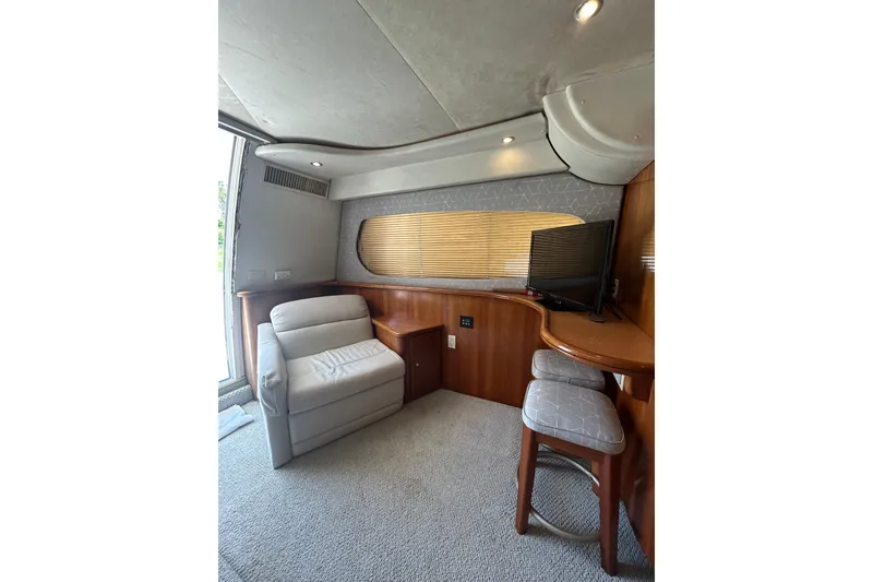 Slide: The Image of Interior of 2001 Silverton 410 Sport Bridge with seating, TV, and wooden accents. - 16