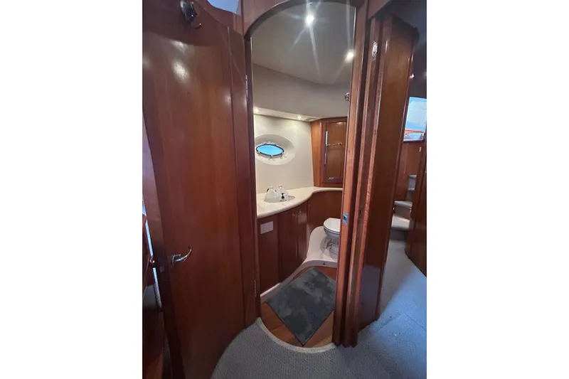 Slide: The Image of Interior of 2001 Silverton 410 Sport Bridge yacht bathroom with wooden cabinetry and porthole window. - 20