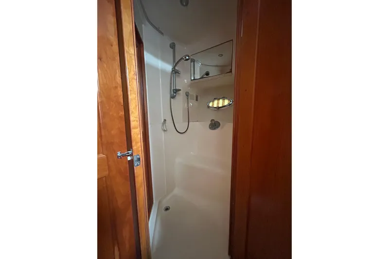 Slide: The Image of Shower area inside 2001 Silverton 410 Sport Bridge yacht, featuring wooden door and modern fixtures. - 21