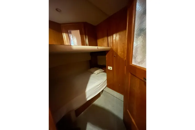 Slide: The Image of Cozy cabin interior of 2001 Silverton 410 Sport Bridge with wooden finish and bunk bed. - 23