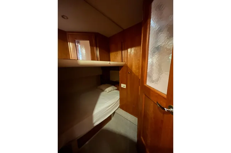 Slide: The Image of Interior cabin of 2001 Silverton 410 Sport Bridge with wooden paneling and bunk bed. - 25