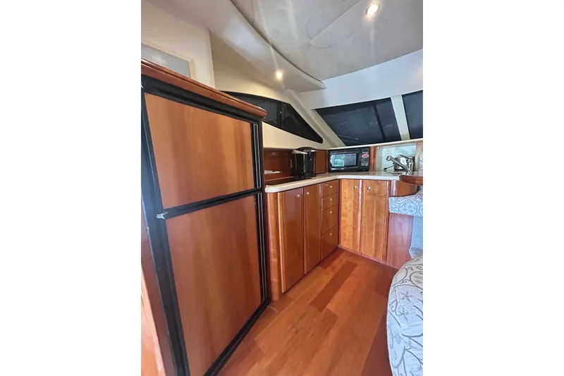 Slide: The Image of Interior of 2001 Silverton 410 Sport Bridge yacht with wood cabinetry and modern appliances. - 31