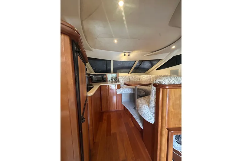 Slide: The Image of Interior of 2001 Silverton 410 Sport Bridge with wood finishes and cozy seating area. - 32