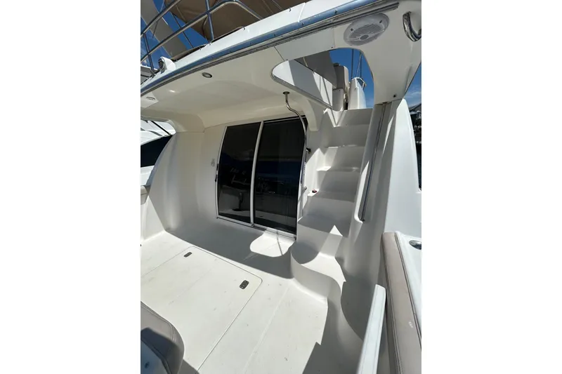 Slide: The Image of 2001 Silverton 410 Sport Bridge yacht with sleek white exterior and staircase. - 4