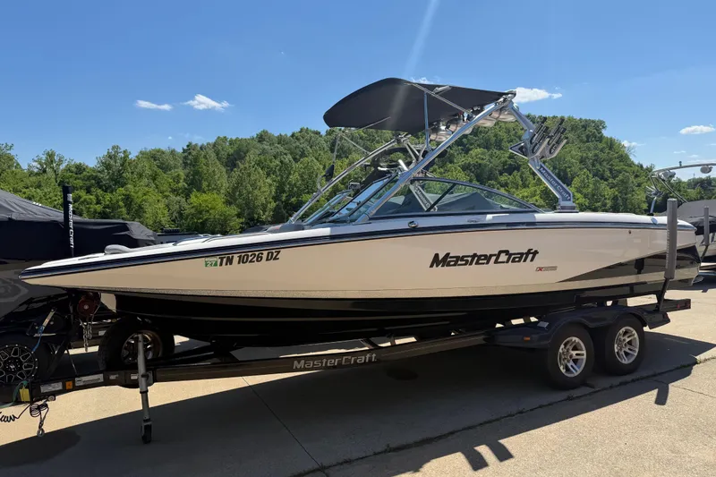 Slide: The Image of 2008 MasterCraft X-45 boat on trailer, parked outdoors under clear blue sky. - 2