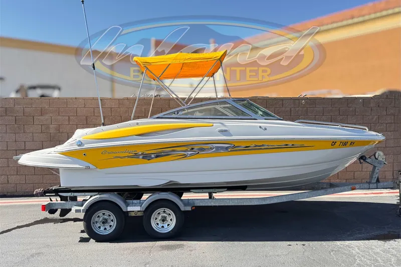 The Image of 2008 Crownline 200 LS boat with yellow accents on a trailer, parked outdoors. - 0
