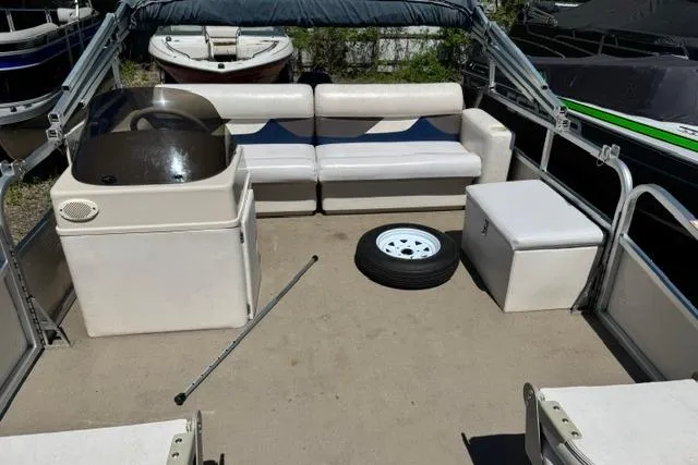 Slide: The Image of 2005 Misty Harbor 1680FS pontoon boat interior with seating, console, and spare tire. - 10