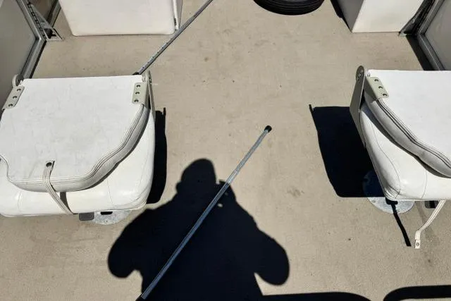Slide: The Image of Interior of a 2005 Misty Harbor 1680FS boat with white seating and shadow. - 14